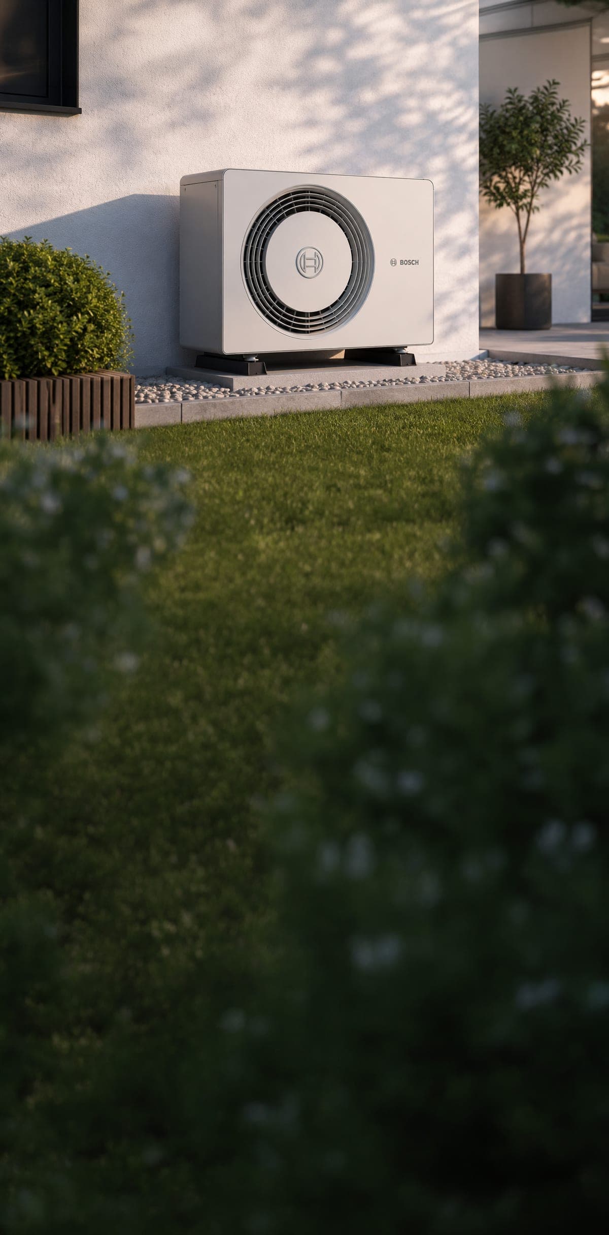 Bosch Luft-Wasser-Wärmepumpe im Garten eines Wohnhauses