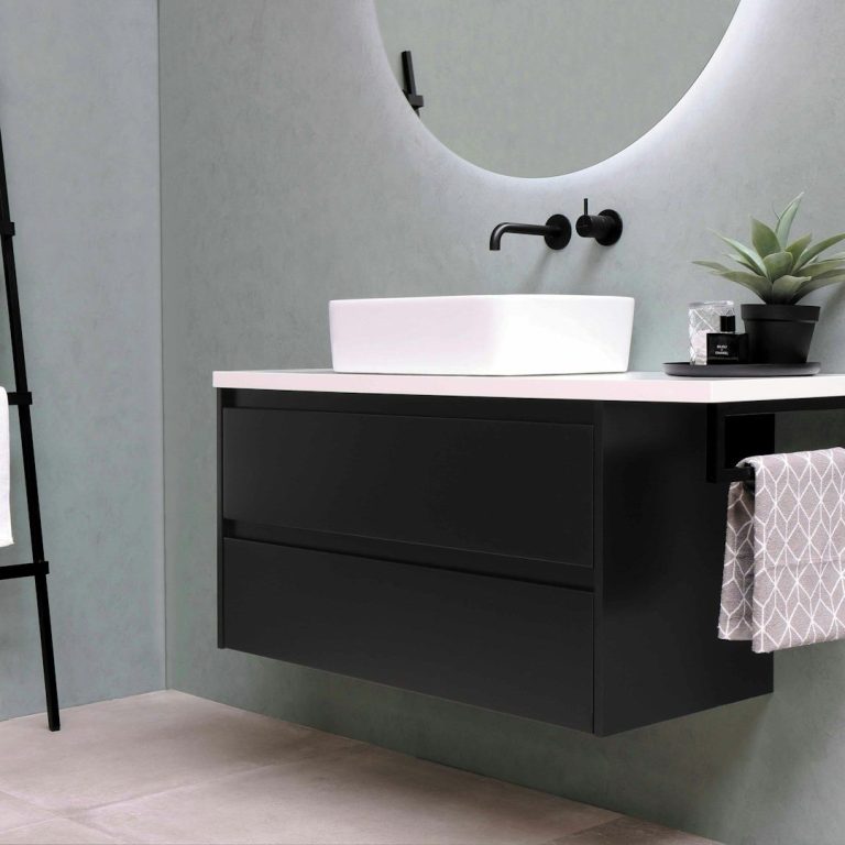 Moderner Badezimmerbereich mit schwarzem Waschbeckenunterschrank und runder Spiegelfläche.