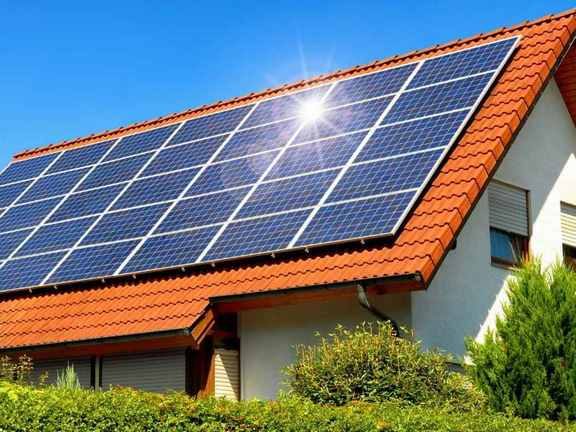 Dach mit Solarpanelen vor blauem Himmel und sonnigem Wetter.